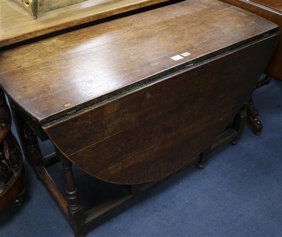 A 17th century style oak gateleg table on turned supports, L.117cm